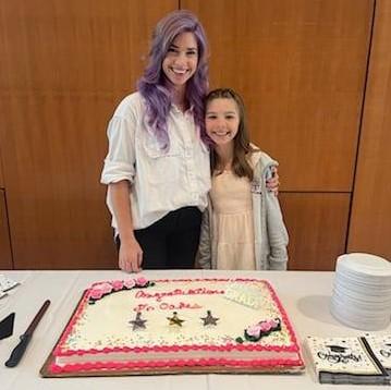 person and a child posing with a cake